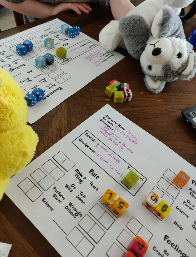 actual gameplay pic from Felt Friendship and Feelings showing our puppets, character sheets, and dice.
