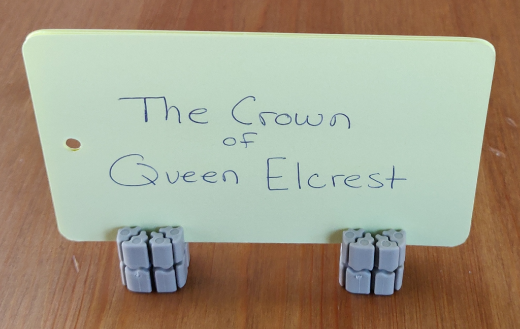 TTRPG item card for a queen's crown - held up on a stand made from Ti'Tains