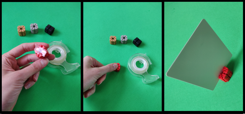 This shows the process for adding adhesive to the bottom of a TI'TAINS card holder.  Double sided tape is applied to the game piece, the piece is then adhered to a green poster board to represent a TTRPG map or playing surface, and a customizable playing card is inserted into the TI'TAINS card holder and is ready for use.