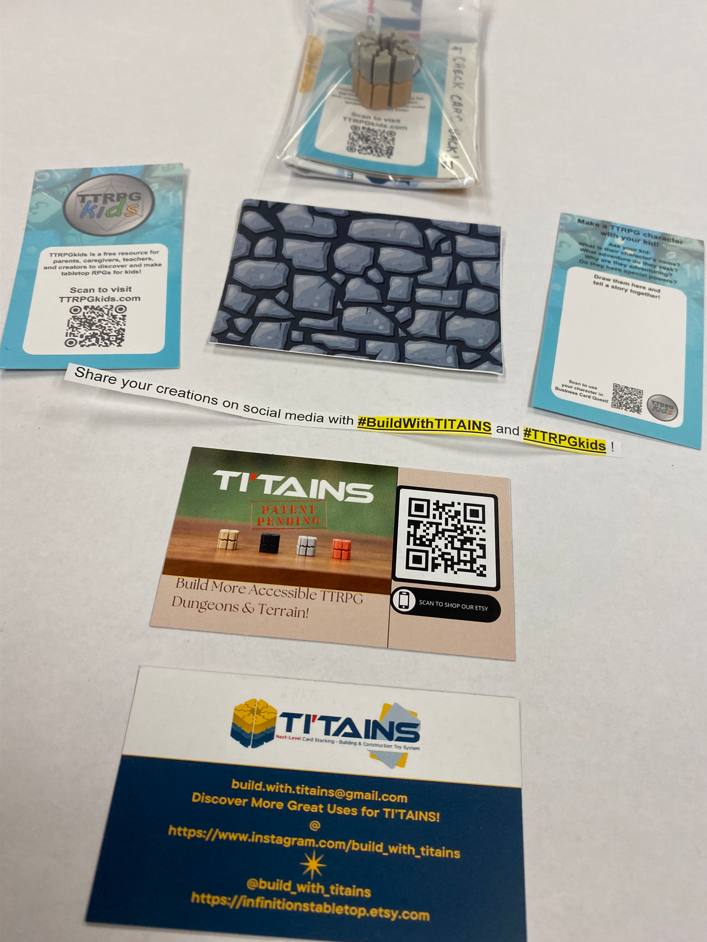 Mini kits being handed out throughout the convention to help others find this page!  It shows the TTRPGkids business card, the TI'TAIN business card, a TI'TAIN card holder, and a dungeon wall that can be used with the TI'TAINS card holder.