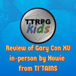 blue dice background with the TTRPGkids logo and text that says "Review of Gary Con XV in-person by Howie from TI'TAINS"