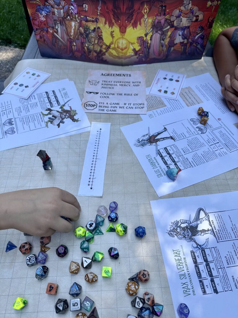 a photo of a TTRPG tabble covered in dice and character sheets
