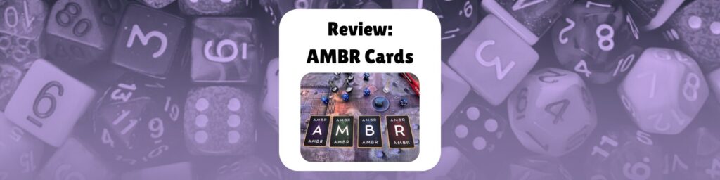 Review: AMBR Cards shows a photo of the AMBR cards, all flipped over and laid out across a gaming table with minis and dice and a map