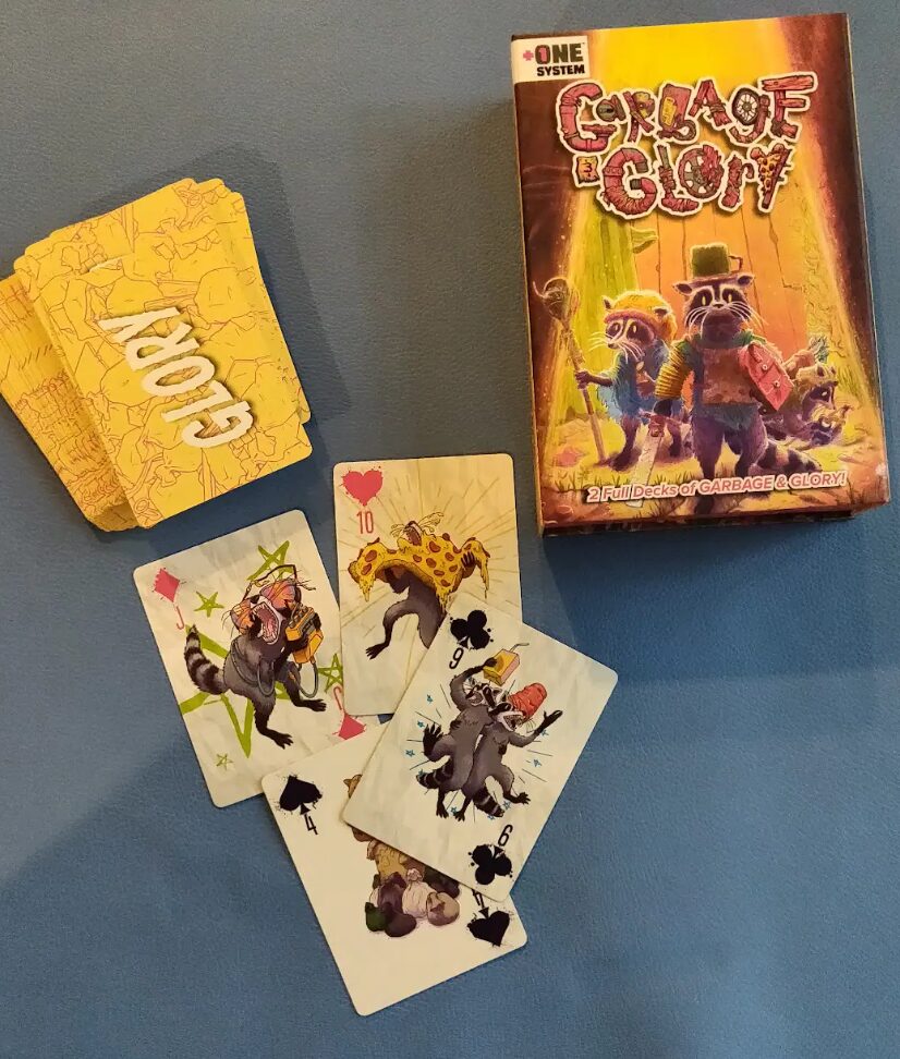 a photo of the Glory deck from Garbage and Glory alongside the card box for the game