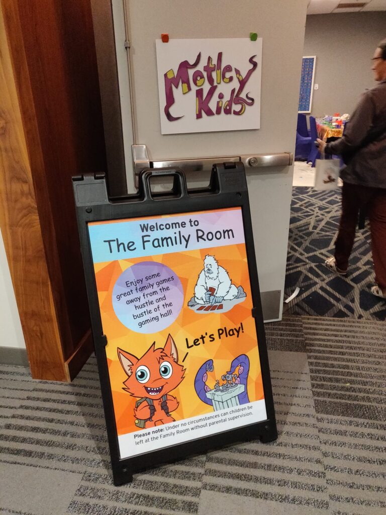 a photo of the entrance to the kids room showing the Motley Kids sign and a sign stand designating the space as "The Family Room"