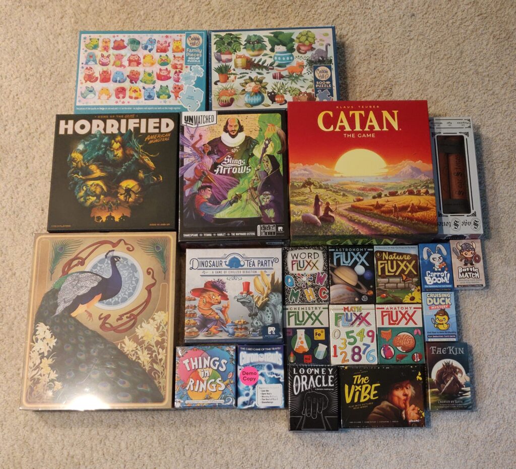 a photo of the games and puzzles Steph got at the convention (there's a couple dozen)