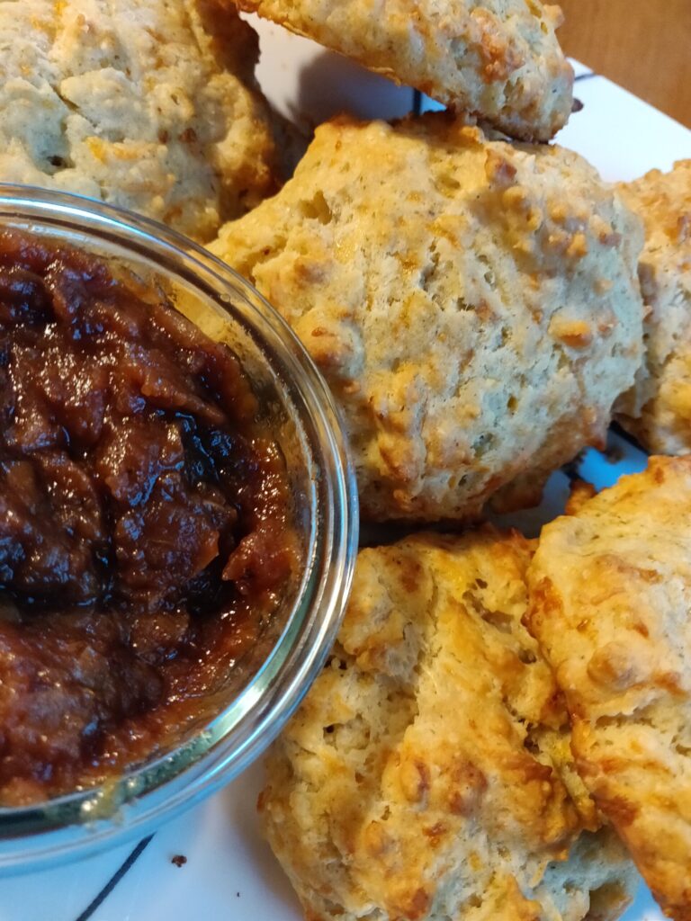 a photo of a plate of buscuits and a small glass dish of apple butter